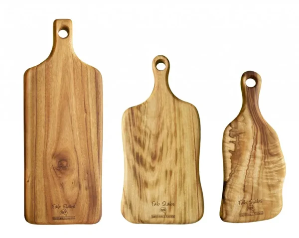 Three wooden cutting boards with a handle on top of them.