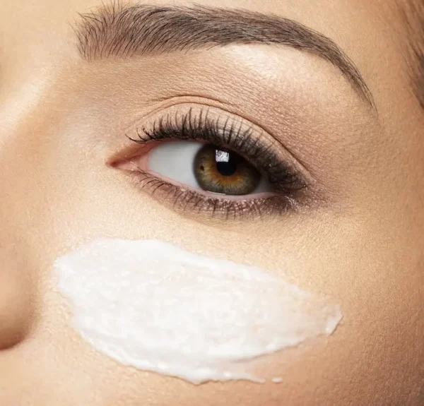 A close up of a woman 's eye with cream on it